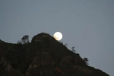 a full moon rising over a mountain at One Love Maktub in Paul do Mar