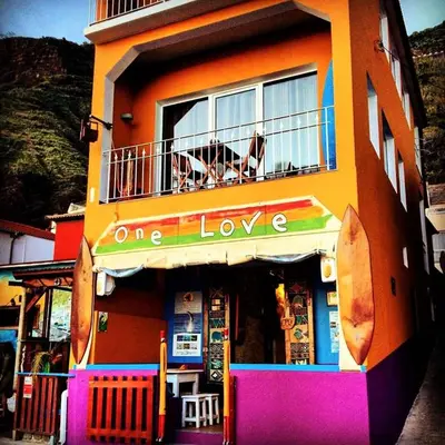 a building with a dog sitting on a balcony at One Love Maktub in Paul do Mar