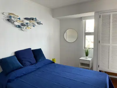 a bedroom with a blue bed and a mirror at Ocean View Studio 2 with pool in Funchal