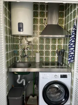 a small kitchen with a sink and a washing machine at Ocean View Studio 2 with pool in Funchal