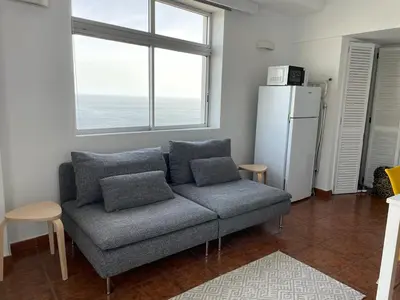 a living room with a couch and a refrigerator at Ocean View Studio 2 with pool in Funchal