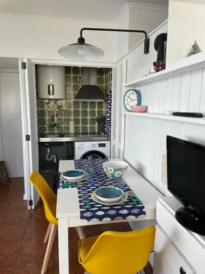 a small kitchen with a table and yellow chairs at Ocean View Studio 2 with pool in Funchal
