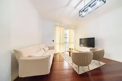 a living room with a white couch and a tv at Home in Funchal in Funchal