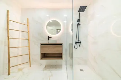 a bathroom with a shower with a sink and a mirror at Home in Funchal in Funchal