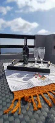 a table with two glasses and a bottle of perfume at O CAMPO na CIDADE in Funchal