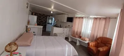 a bedroom with a bed and a chair and a kitchen at O CAMPO na CIDADE in Funchal