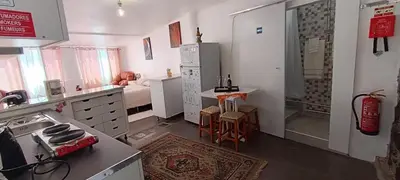 a kitchen with a refrigerator and a table in it at O CAMPO na CIDADE in Funchal