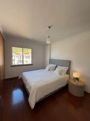 a bedroom with a large white bed and a window at BelleMar Vacations in Funchal