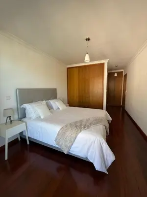 a bedroom with a large bed with a wooden headboard at BelleMar Vacations in Funchal