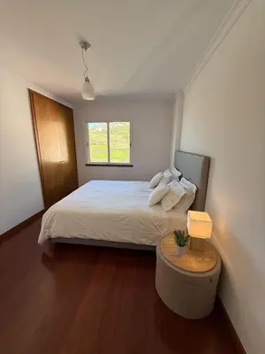 a bedroom with a bed and a table with a lamp at BelleMar Vacations in Funchal