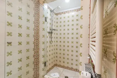 a bathroom with a shower with floral wallpaper at Spacious villa with sea view, tennis & golf garden #1963 in Alagoas