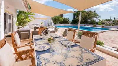 a patio with a table and chairs and a swimming pool at Spacious villa with sea view, tennis & golf garden #1963 in Alagoas