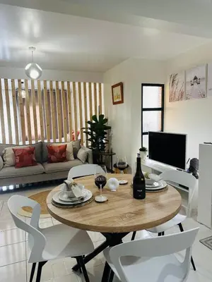 a living room with a wooden table and white chairs at Dani House - Porto Moniz Escape in Porto Moniz