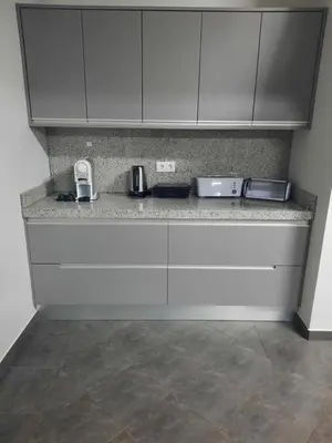 a kitchen with white cabinets and a counter top at Rose Sun House in Ponta do Sol