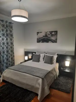 a bedroom with a large bed with a view of the eiffel tower at Rose Sun House in Ponta do Sol