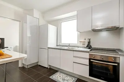 a kitchen with white cabinets and a sink and a window at Sunflower Living by Homie in Caniço