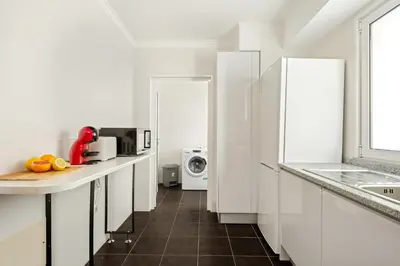 a white kitchen with a sink and a microwave at Sunflower Living by Homie in Caniço