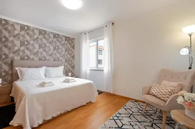 a bedroom with a bed and a chair at Sunflower Living by Homie in Caniço