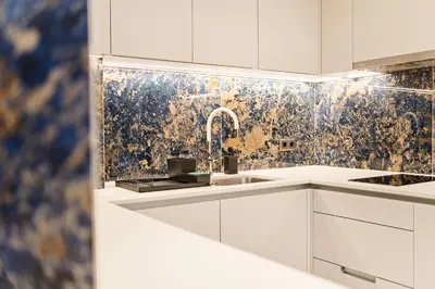 a white kitchen with a sink and a mosaic wall at Safira Suites 101 in Funchal