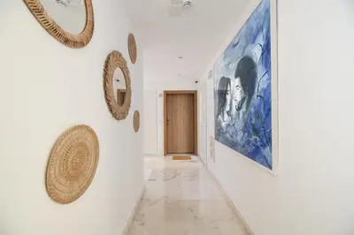 a hallway with paintings on the wall and a door at Safira Suites 101 in Funchal