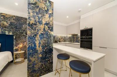 a kitchen with blue and gold wallpaper and two stools at Safira Suites 201 in Funchal