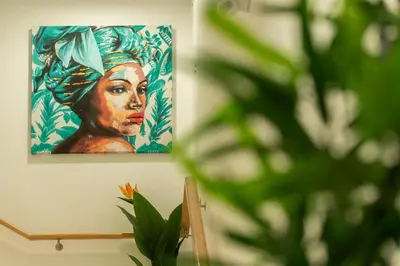 a painting of a woman is hanging on a wall at Safira Suites 202 in Funchal