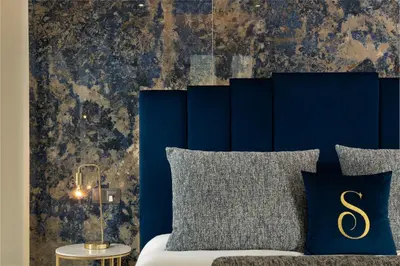 a bedroom with blue walls and a bed with blue pillows at Safira Suites 202 in Funchal