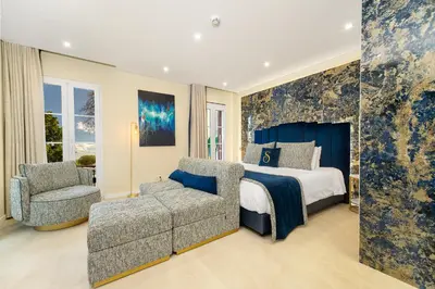 a bedroom with a bed and a couch and a chair at Safira Suites 301 in Funchal