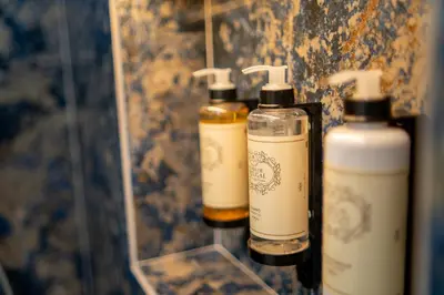 three bottles of soap on a shelf in a bathroom at Safira Suites 301 in Funchal