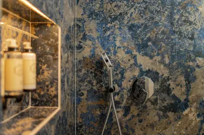 a bathroom with a shower with a camera on the wall at Safira Suites 302 in Funchal