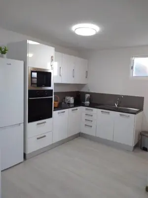 a kitchen with white cabinets and a black appliance at Casa Ponte in Ponta do Sol