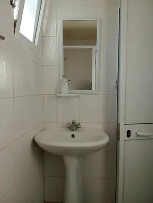 a white bathroom with a sink and a mirror at Casa Ponte in Ponta do Sol