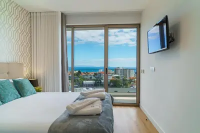a bedroom with a large bed with a large window at GuestReady - The perfect place to relax in Funchal in Funchal