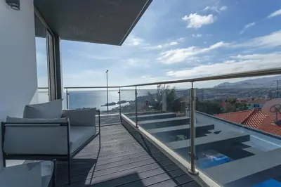 a balcony with a chair and a view of the ocean at Villa Andrade Ocean View in Funchal