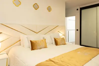 a bedroom with a large white bed with gold pillows at Villa Andrade Ocean View in Funchal