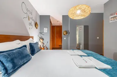a bedroom with a large white bed with blue pillows at FLH Funchal Sissi Lanço with View in Funchal