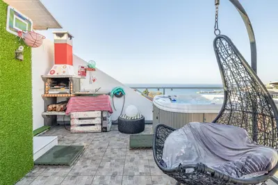 a swing on a patio with the ocean in the background at FLH Funchal Sissi Lanço with View in Funchal