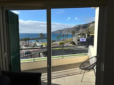 a room with a view of the ocean from a balcony at 4 Saints apartement in Ribeira Brava