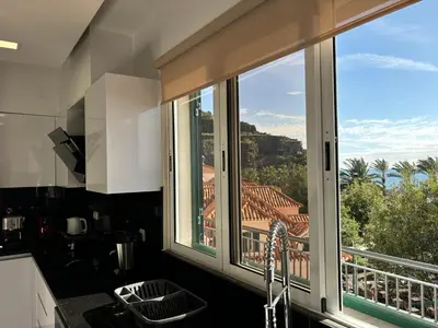 a kitchen window with a view of a house at 4 Saints apartement in Ribeira Brava