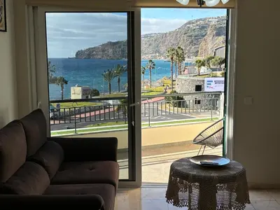 a living room with a couch and a view of the ocean at 4 Saints apartement in Ribeira Brava