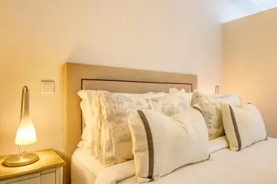 a bedroom with a bed with white pillows and a lamp at Elsa's Place, a Home in Madeira in Funchal