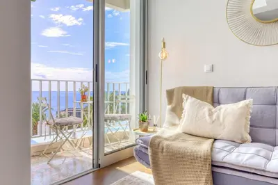 a living room with a couch and a balcony at Elsa's Place, a Home in Madeira in Funchal