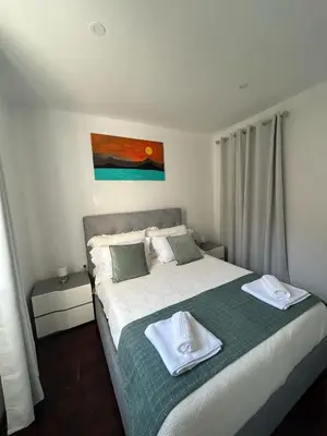 a bedroom with a bed with two towels on it at Villa R Relíquia in Machico