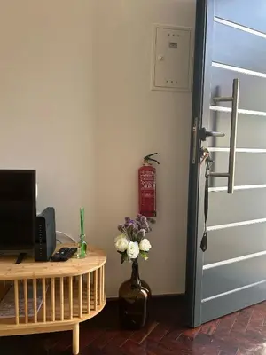 a room with a door and a vase with flowers on a table at Villa R Relíquia in Machico