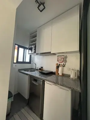 a kitchen with white cabinets and a counter top at Villa R Relíquia in Machico