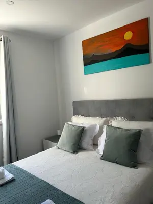 a bedroom with a bed with green and white pillows at Villa R Relíquia in Machico