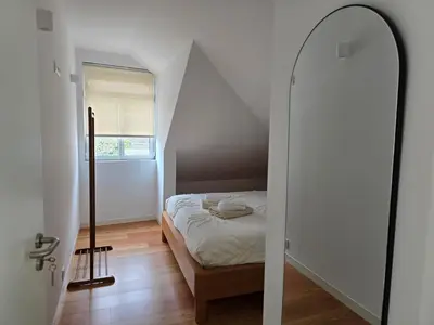 a small bedroom with a bed and a mirror at Ficus Suites in Ponta do Sol