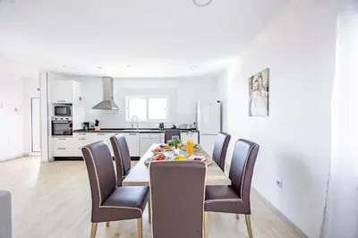 a kitchen and dining room with a table and chairs at Azur & Bellevue du Caniço by YOUR KEY in Caniço