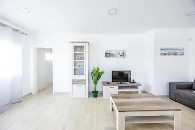 a white living room with a couch and a table at Azur & Bellevue du Caniço by YOUR KEY in Caniço