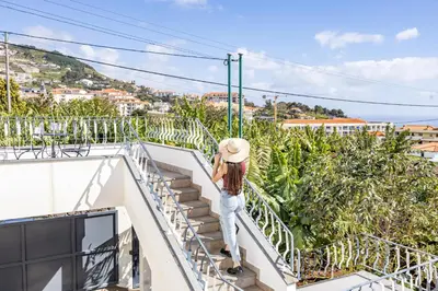 a woman standing on a balcony looking at a banana plantation at Azur & Bellevue du Caniço by YOUR KEY in Caniço